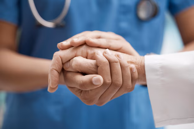 Medic oncolog ținând de mână un pacient, oferind suport și empatie